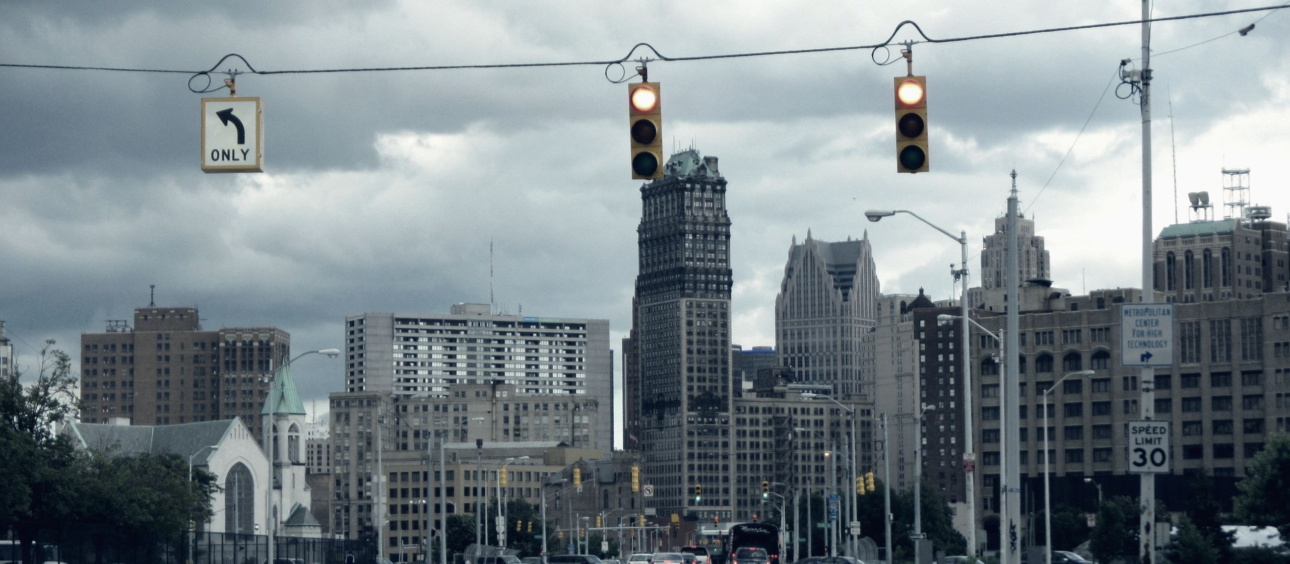 Grand River Avenue running into downtown Detroit under a heavy sky.